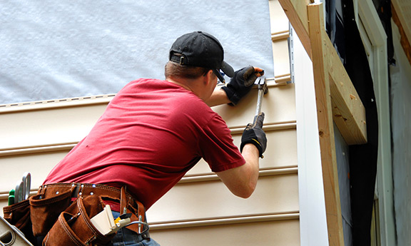 Worker putting up vinyl siding