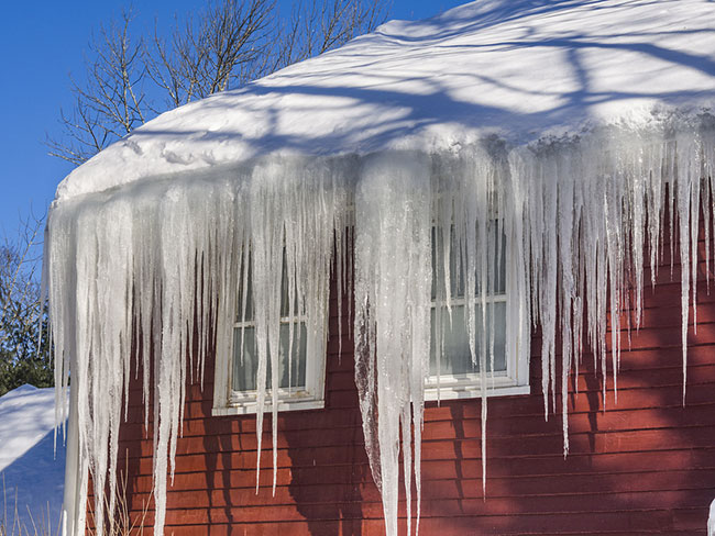 bigstock-ice-dams-and-snow-on-roof-and-82911134