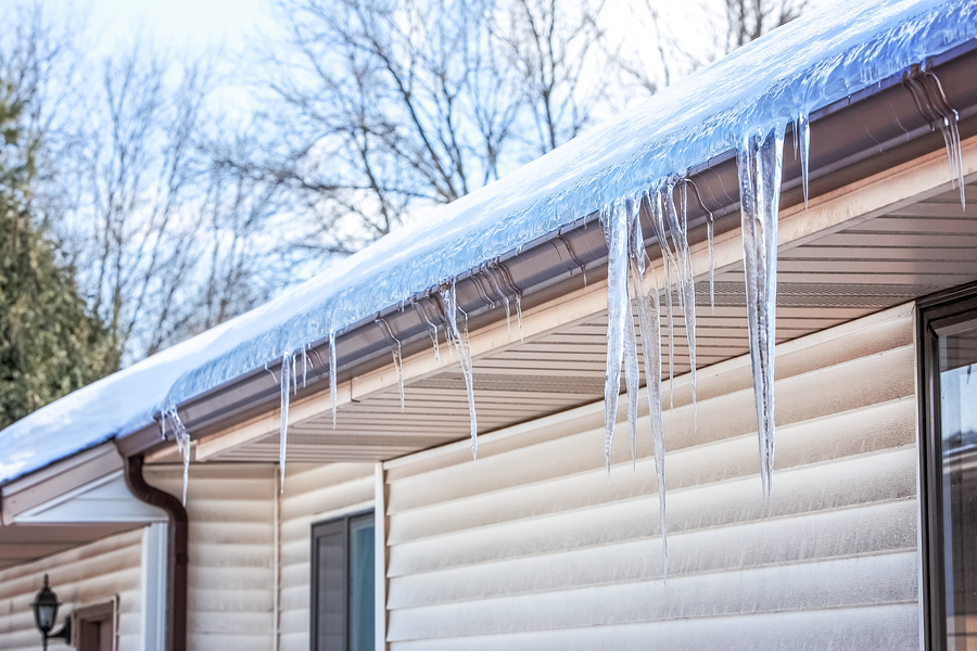 A residential roof with snow and ice.