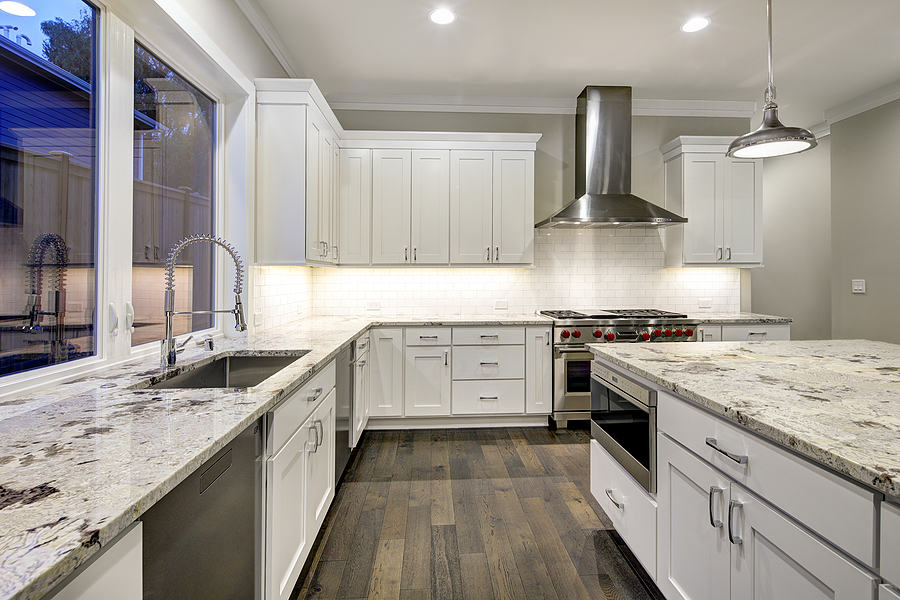 Large spacious kitchen design with white kitchen cabinets white kitchen island with lots of storage white Granite countertops subway tiles and stainless steel appliances.