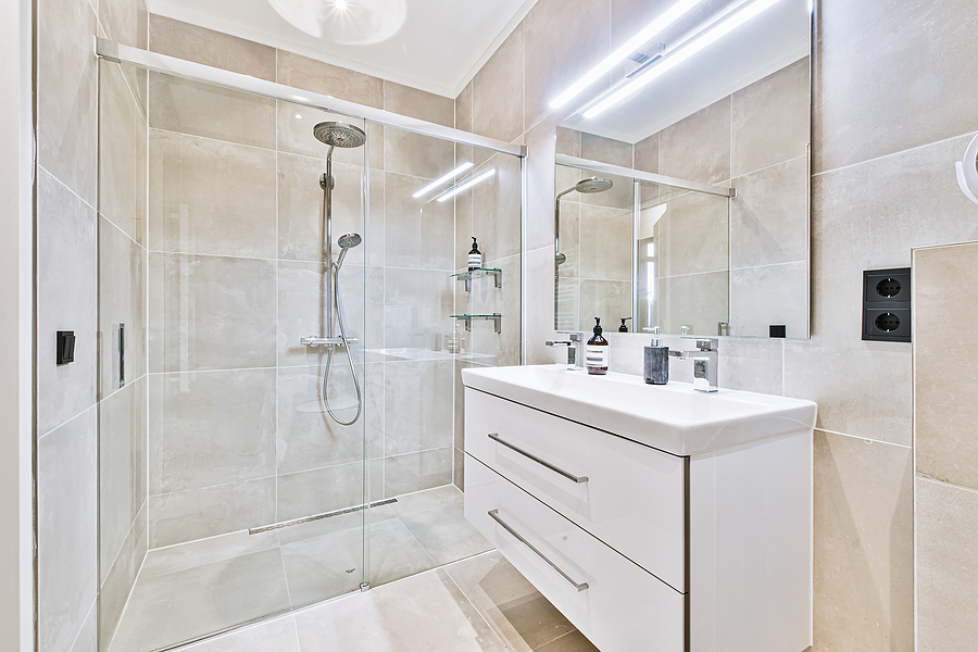 Fresh, trendy new bathroom with tiled walls and floors and a floating vanity.