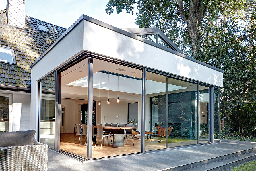 Updated home with modern sunroom addition on a sunny day.