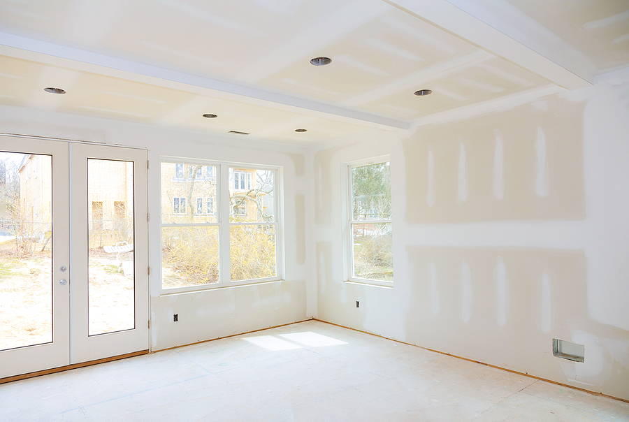 Progress of a home improvement project with new windows and doors and a newly opened floor plan.