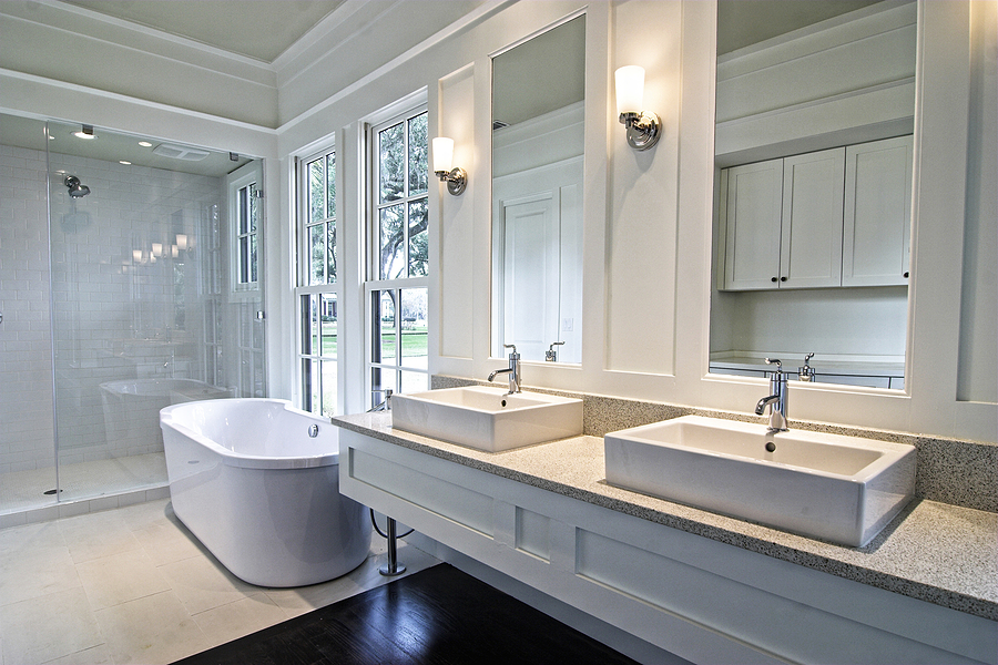 Modern spacious white bathroom with dark wood floors and modern fixtures.