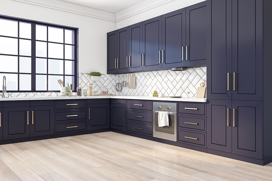 New kitchen with a large window over the sink and dark blue cabinets lining two walls.