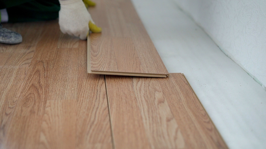 Home improvement contractor installing vinyl flooring.