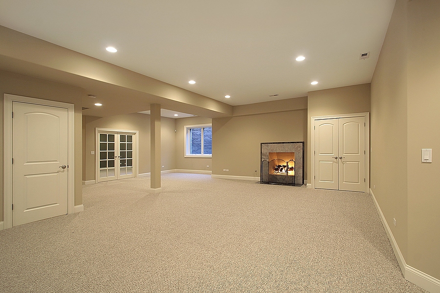 Finished basement with in-ceiling lights, beige walls, carpet, and a fireplace