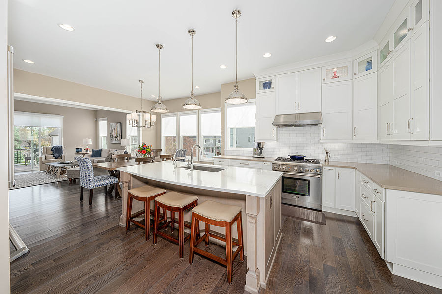 remodeled open concept kitchen with large island, white walls, cupboards, and countertops