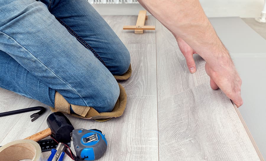 Contractor installing new flooring for home renovation.