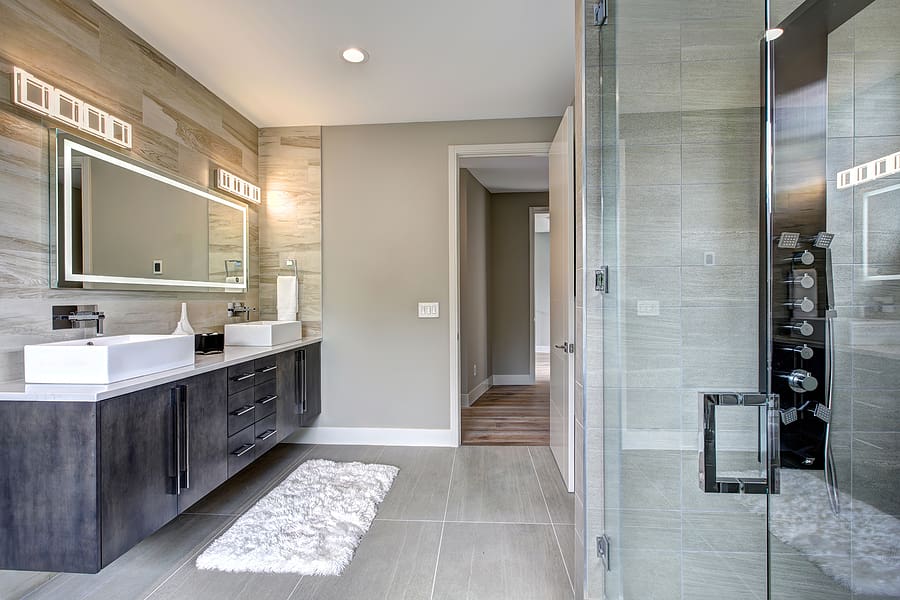 Modern, contemporary bathroom with double vanity and tiled walk-in shower. 