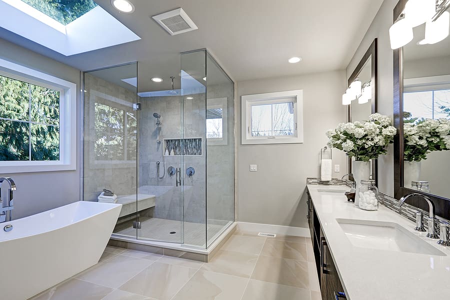 Modern, luxury bathroom in gray tones with freestanding soaker tub and large walk-in shower. 