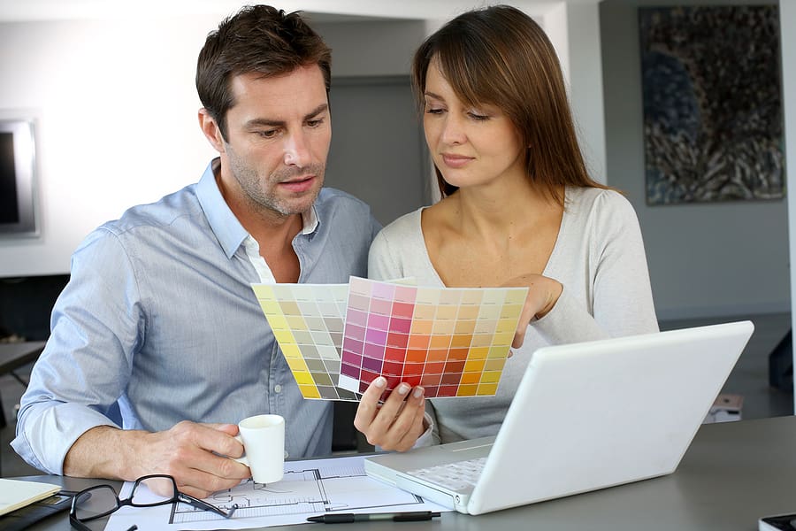 Couple sitting down with laptop open, making decisions about their upcoming home renovation. 