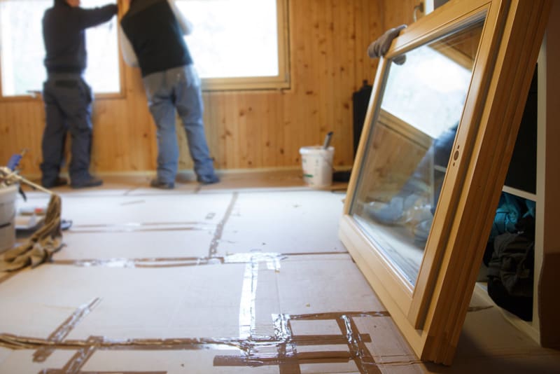 Two men installing windows in a home.