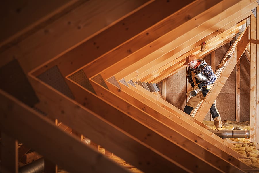 Professional roofer installing ventilation ducts in the roof. 